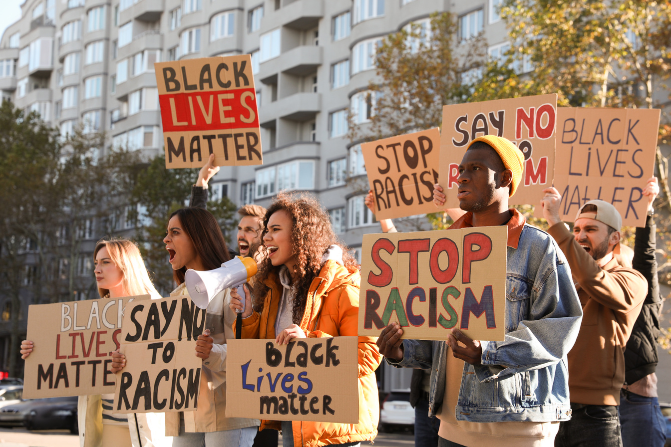 Protesters Demonstrating Different anti Racism Slogans Outdoors.
